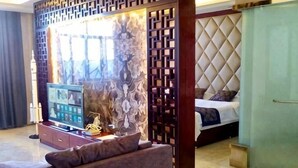A modern hotel room with a TV, a sofa, a bed, and a decorative wall. - Jintaolai Hotel (Ejin Banner)
