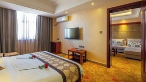 Una habitación de hotel con cama, televisión, escritorio y sofá.