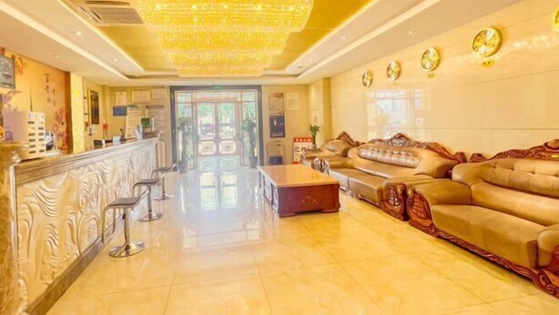 A lobby with a chandelier, a reception desk, a sofa, and a coffee table. - Jintaolai Hotel (Ejin Banner)