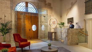 A lobby with a reception desk, a wooden door, and a large arched window. - Axel Hotel Valencia – Adults Only (Valencia)