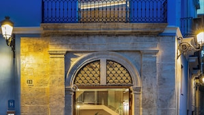 A hotel entrance with a glass door, a balcony with a railing, and a sign indicating the hotel name. - Axel Hotel Valencia – Adults Only (Valencia)
