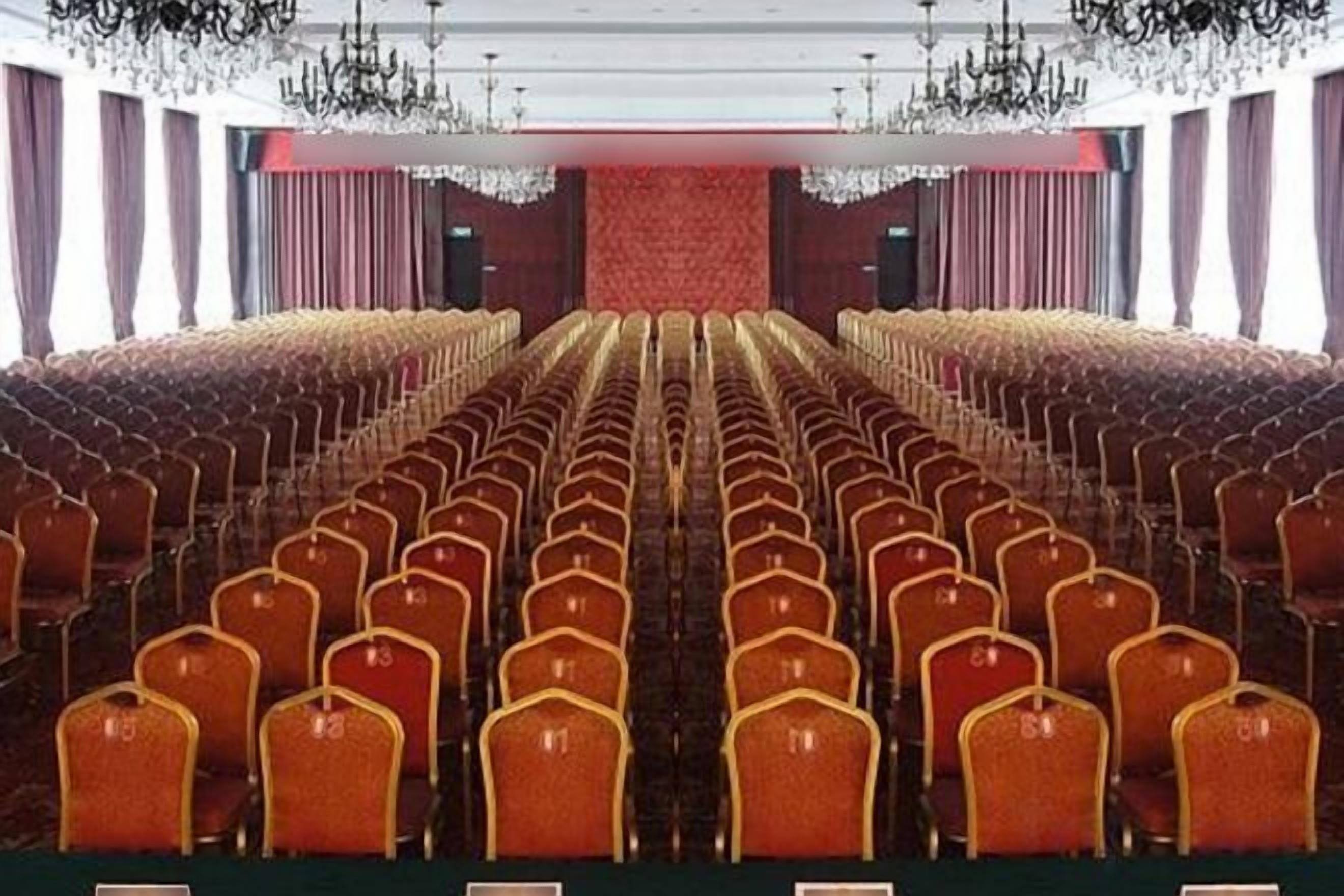 Un teatro con hileras de asientos y un escenario.