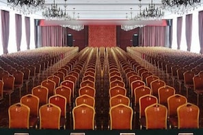 A theater with rows of chairs and a stage.