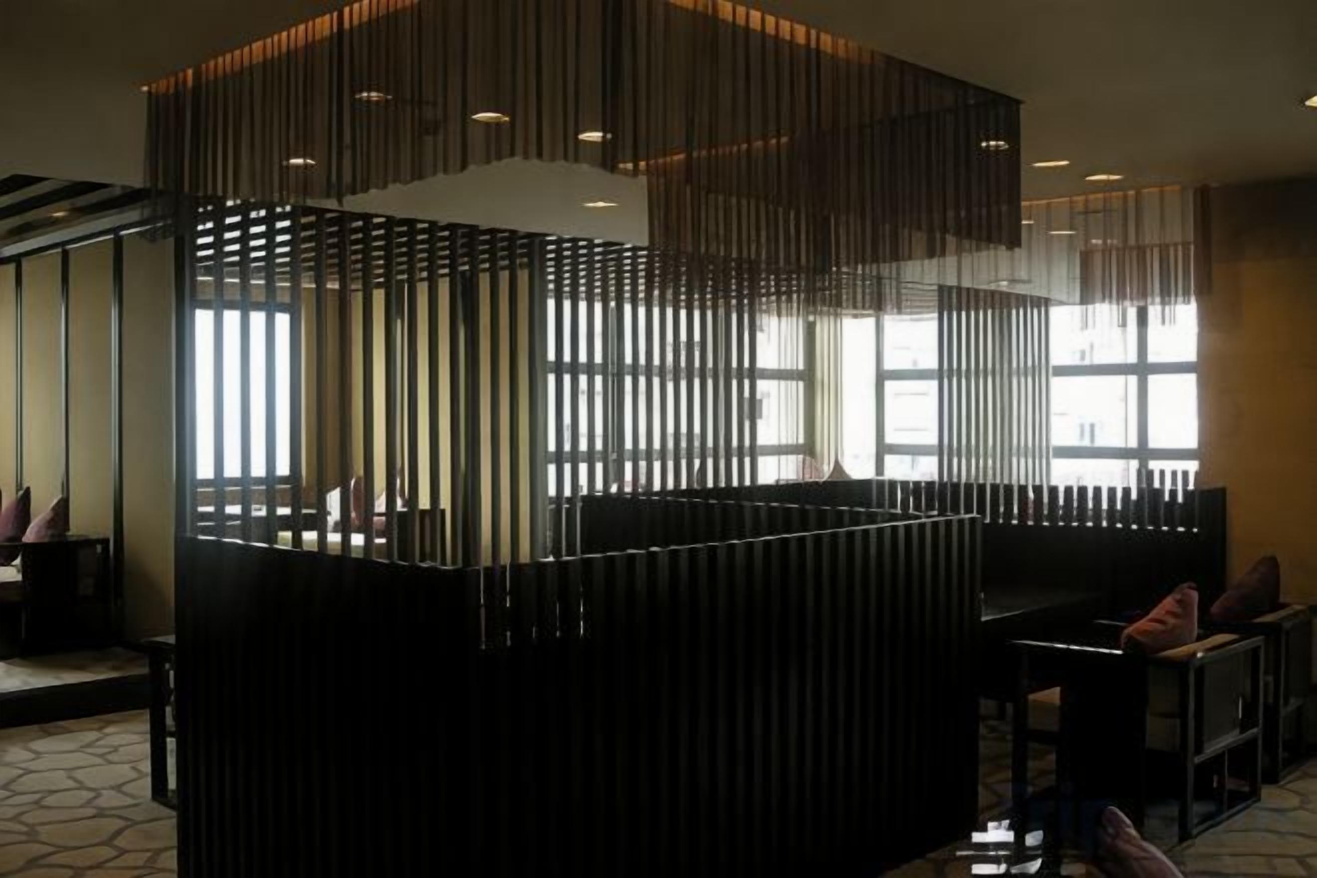 Un interno moderno con reception, area relax e ampie finestre che lasciano entrare luce naturale.