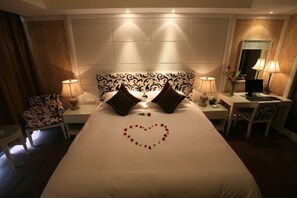 Een hotelkamer met een groot bed, twee nachtkastjes, een bureau en een stoel.