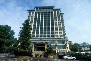 Un hôtel à plusieurs étages, doté d’un design moderne, avec une entrée imposante et un espace de stationnement situé à l’avant.