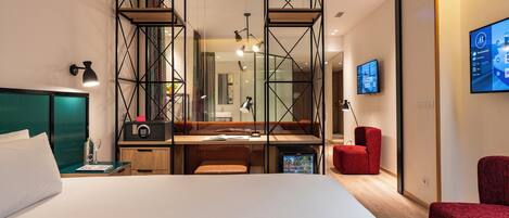 Una habitación de hotel moderna con cama, escritorio y zona de estar.