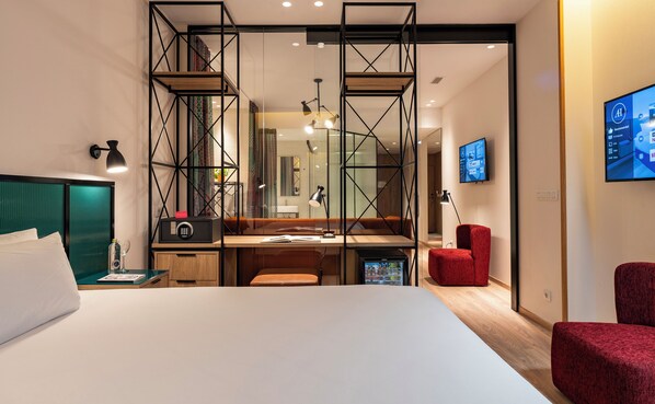 Una habitación de hotel moderna con cama, escritorio y zona de estar.