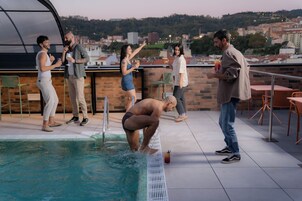 Area piscina sul tetto con vista sullo skyline urbano.