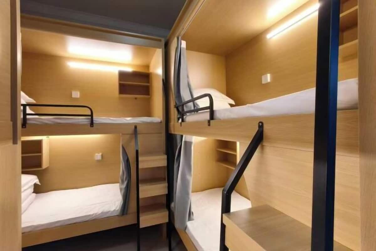 A bunk bed room with wooden walls and metal railings.