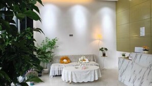 Un moderno vestíbulo de hotel con mostrador de recepción, zona de estar y grandes ventanales.
