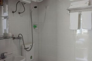 A bathroom with a shower, sink, and toilet.