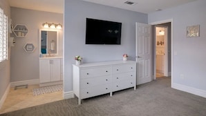 A modern bathroom with a vanity, mirror, and a shower area. - Desert Lily - 6 Pools, Pickle Ball & Tennis Courts, 2 Patios (Palm Springs)