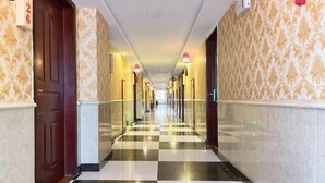 A hotel corridor with checkered flooring, patterned wallpaper, and doors on both sides. - Kaerlaisi Boutique Stay (Dongguan Chang'an) (Dongguan)