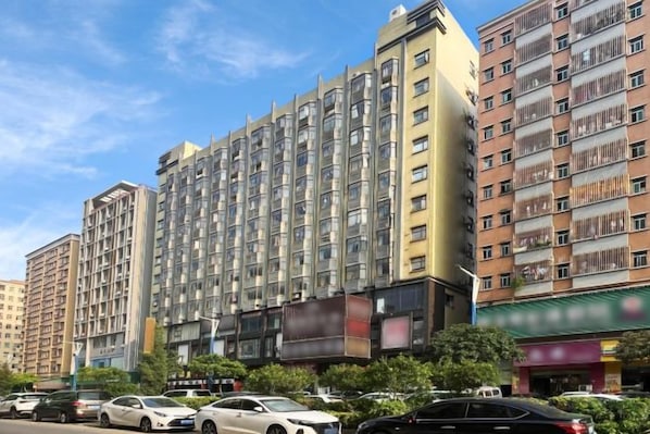 A multi-story hotel with a modern facade, several balconies, and a parking lot with cars. - Kaerlaisi Boutique Stay (Dongguan Chang'an) (Dongguan)