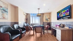 A hotel room with a dining area, a TV mounted on the wall, and a view of the city through the window. - Kaerlaisi Boutique Stay (Dongguan Chang'an) (Dongguan)