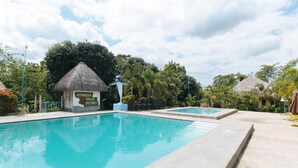A swimming pool area with a thatched-roof structure labeled 'Atamosa Villas Resort.' - Reddoorz @ Afamosa Villas Resort Ilocos Sur (San Juan)