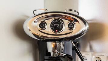 A coffee machine with two cups of coffee on a table.