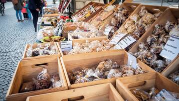 A market stall with various food items displayed in wooden crates, including dried fruits and nuts.