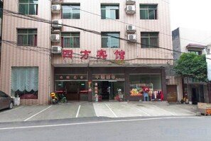 Un edificio con un letrero que dice 'Xiangfu Hotel'. Se observan varias ventanas y una entrada visible.