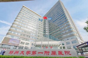 A modern building with multiple floors, a prominent entrance with a glass facade, and signage indicating it is a medical facility. - Homeinn Pebble Hotel (Zhengzhou Jinshui Road Medical College) (Zhengzhou)