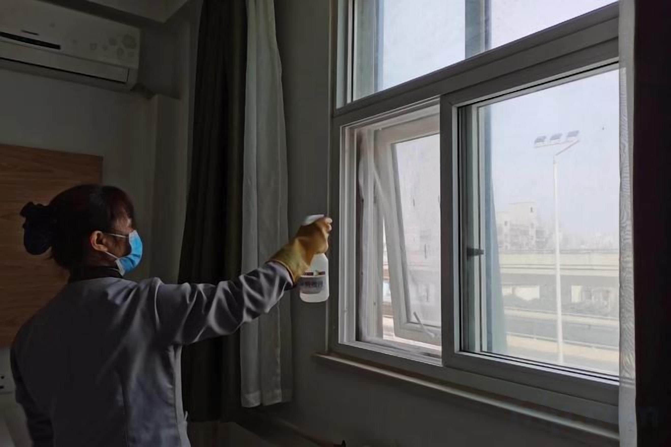 A person cleaning a window with a spray bottle.