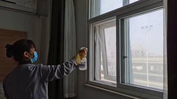 A person cleaning a window with a spray bottle.