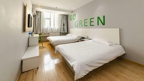 Een hotelkamer met twee bedden, een bureau, een stoel, een televisie en een raam met gordijnen.