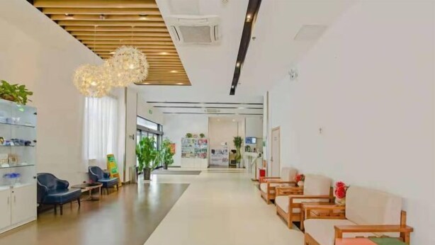Eine moderne Lobby mit Holzboden, Sitzbereichen und einer Rezeption.
