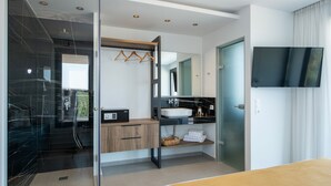 Een moderne badkamer met een glazen douchecabine, een houten wastafelmeubel, een wastafel en een spiegel.
