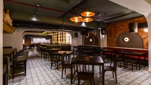 Un restaurant au décor moderne, doté d’un bar, de plusieurs espaces de restauration et d’un four à pizza original.