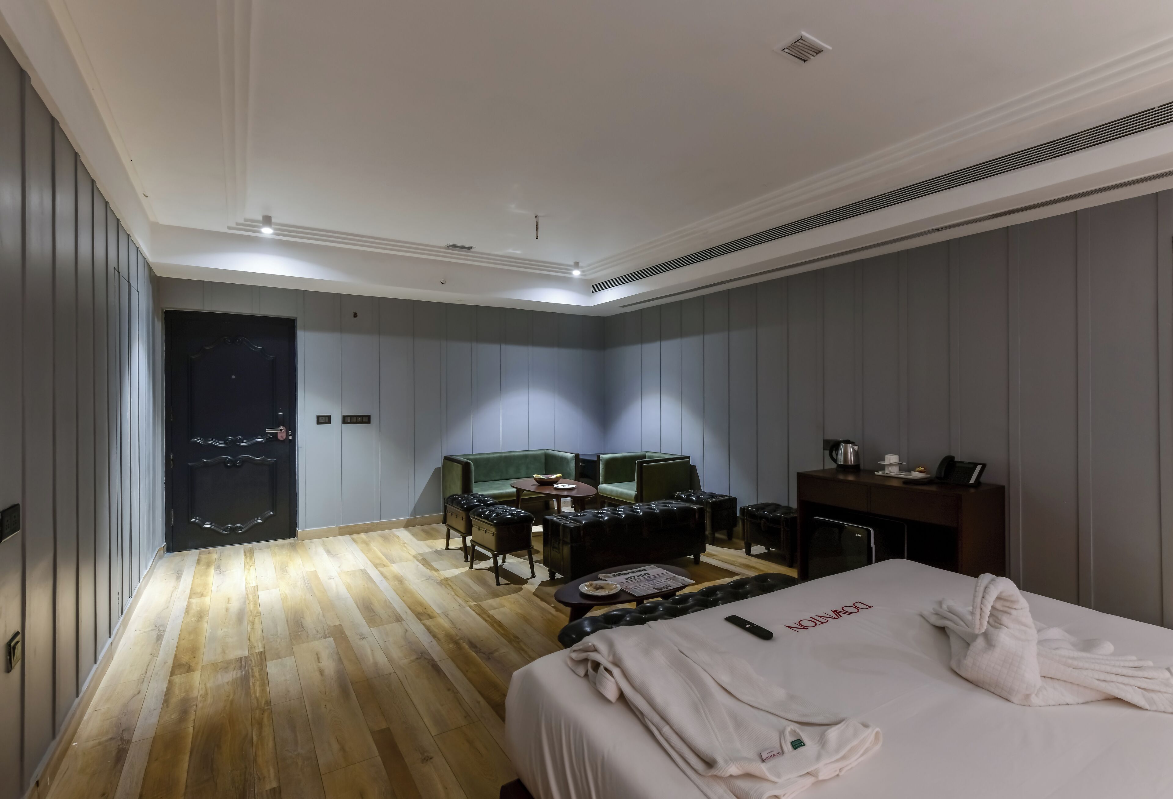 Een hotelkamer met een bed, een bureau, een stoel, een klein tafeltje en een bank.
