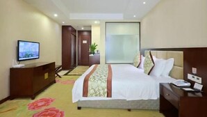 A hotel room with a bed, a TV, a desk, and a plant. - Fulong Hotel (Ya'an)