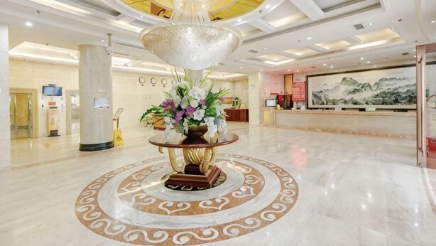A lobby with a central fountain, a reception desk, and a large mural on the wall. - Fulong Hotel (Ya'an)