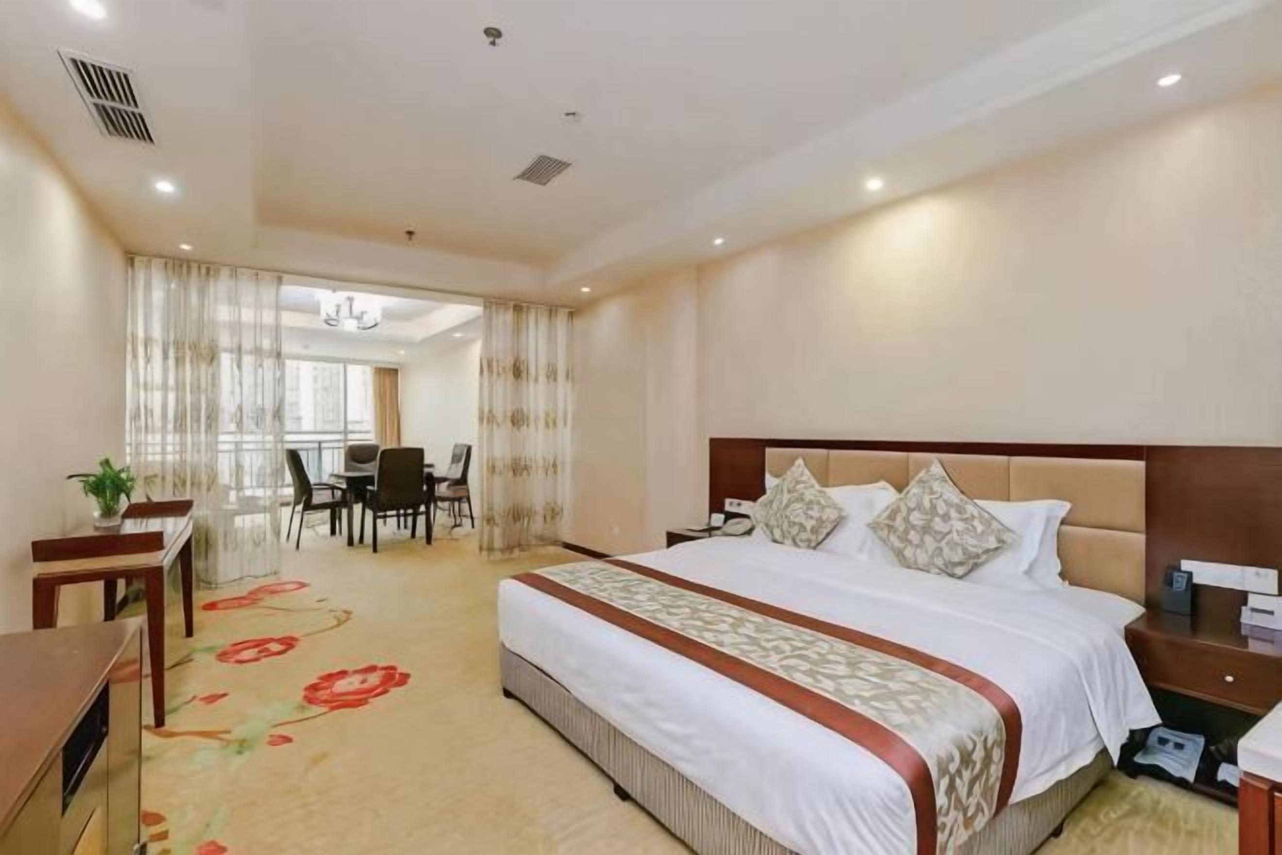 Une chambre d’hôtel avec un grand lit, un bureau et une chaise.
