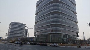 Ein modernes Gebäude mit einer geschwungenen Fassade und mehreren Balkonen.