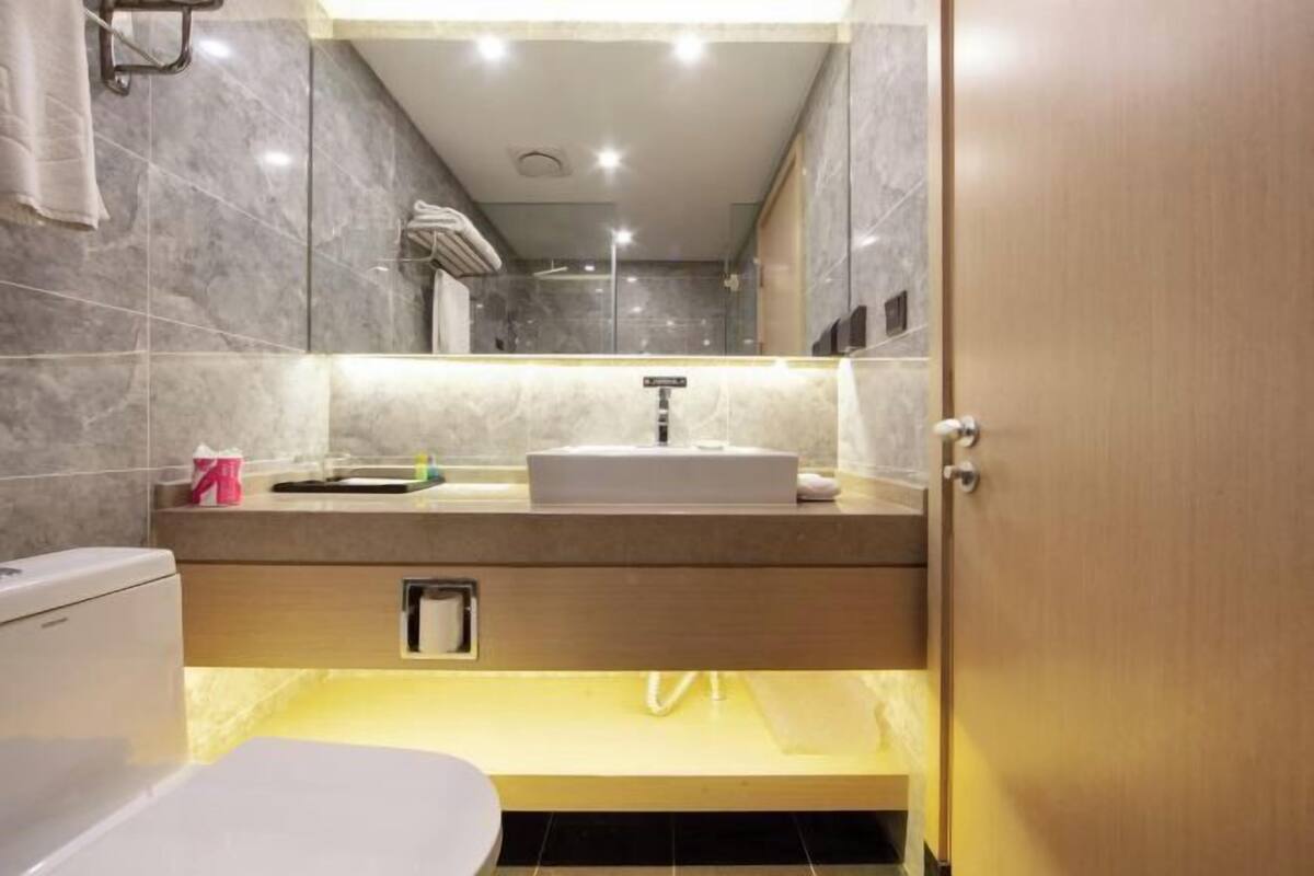 Une salle de bain moderne avec un lavabo en marbre, des toilettes et un espace douche.