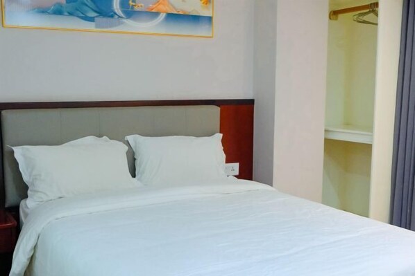 A neatly made bed with white bedding in a hotel room. - Jiang Su Hotel (Kathmandu)