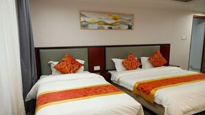A hotel room with two beds, each with white bedding and orange accents, a painting above the beds, and a wooden headboard. - Jiang Su Hotel (Kathmandu)