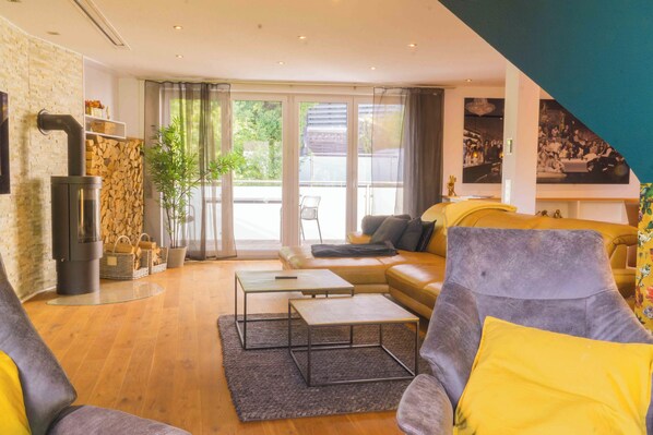 Relax in a spacious living room with a fireplace, comfortable seating area, and large window.