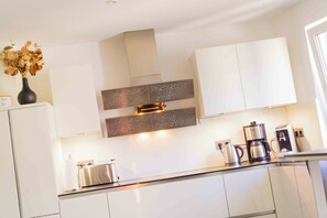 Welcome to a stylish kitchen with a central island, white cabinetry, and a decorative backsplash.