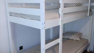 A bunk bed with a lower bunk and a mattress on the floor.