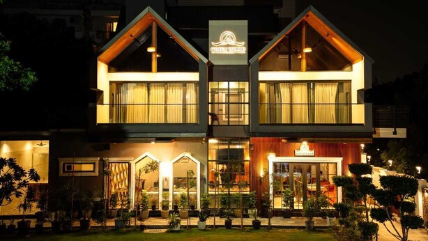 A two-story building with a restaurant sign, large windows, and a well-lit entrance.