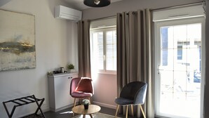 A modern living room with a large window, a kitchen area, and a seating arrangement. - La Chartreuse-Bordeaux (Bordeaux)