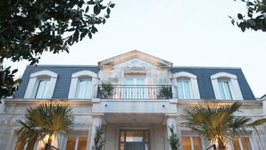 A grand building with a symmetrical facade, large windows, and a central entrance with a decorative door. - La Chartreuse-Bordeaux (Bordeaux)