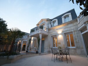 A large, elegant house with a spacious patio, a balcony, and a dining area with outdoor furniture. - La Chartreuse-Bordeaux (Bordeaux)
