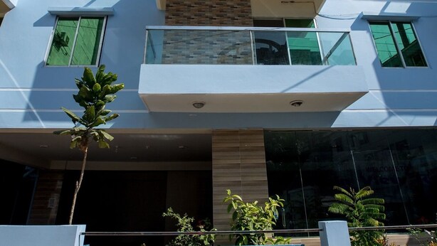 A modern building with a balcony, large windows, and a reflective glass facade. - Resort Rain View Hotel Cox's Bazar (Cox's Bazar)