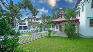 A residential area with a well-maintained lawn, a swimming pool, and multiple houses with red roofs. - The Grand Bliss, Kottawa, 3-bedroom villa with AC, WiFi, Private Pool, and Gym (Pannipitiya, Kottawa)