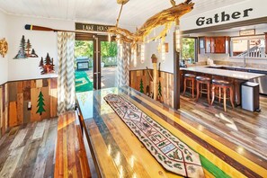 A lodge with a central bar area, wooden flooring, and a sign reading 'Lake House.'