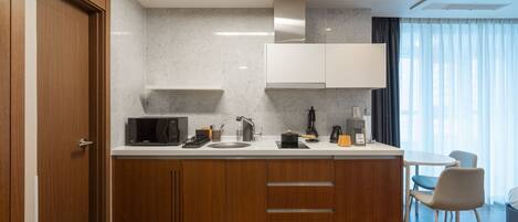 A modern kitchen with wooden cabinets, a microwave, a sink, and a coffee maker.